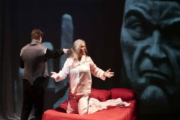 a person pointing at a person on a bed