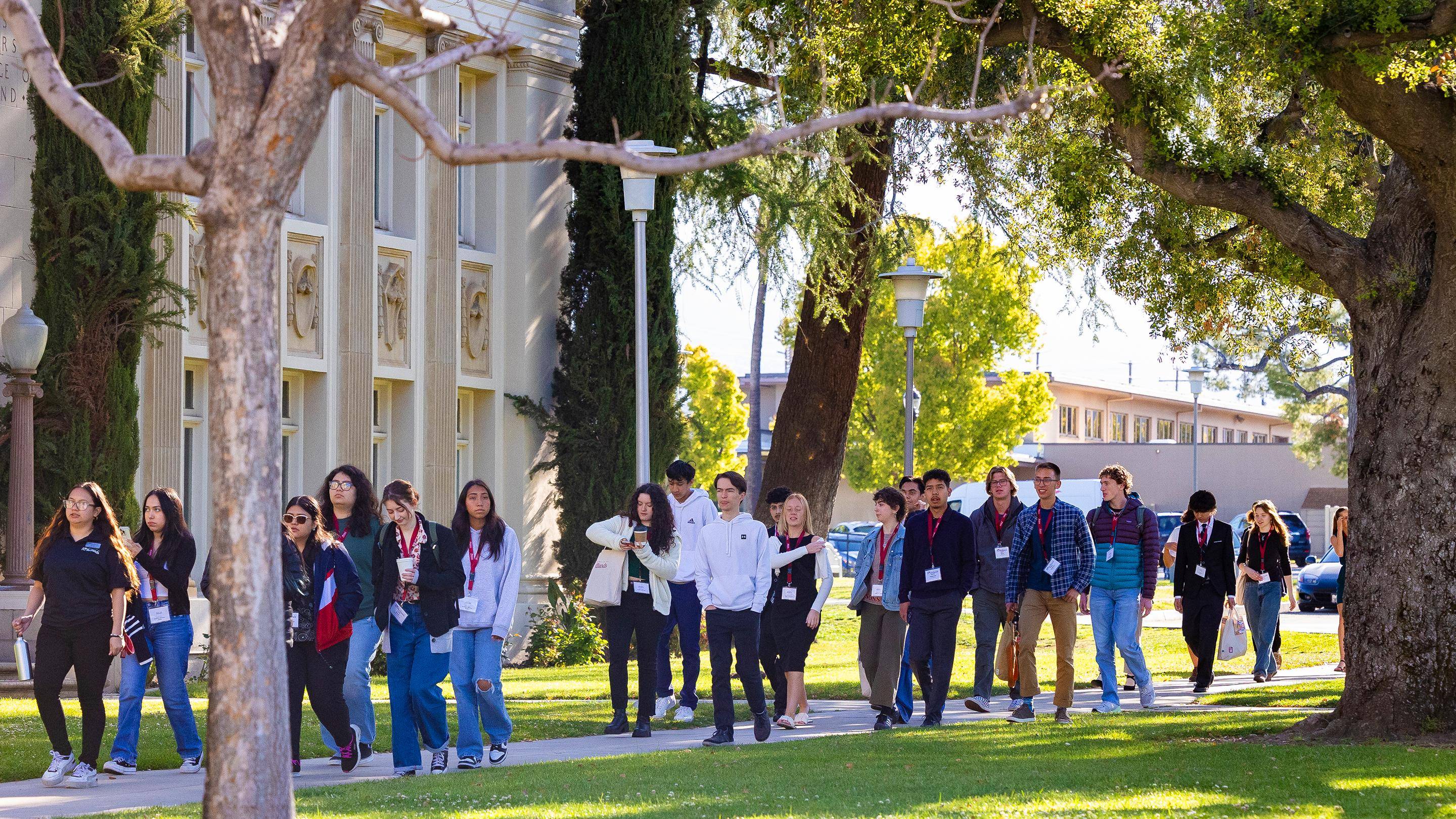a group of people walking on a sidewalk