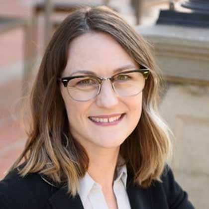 a person wearing glasses and a suit