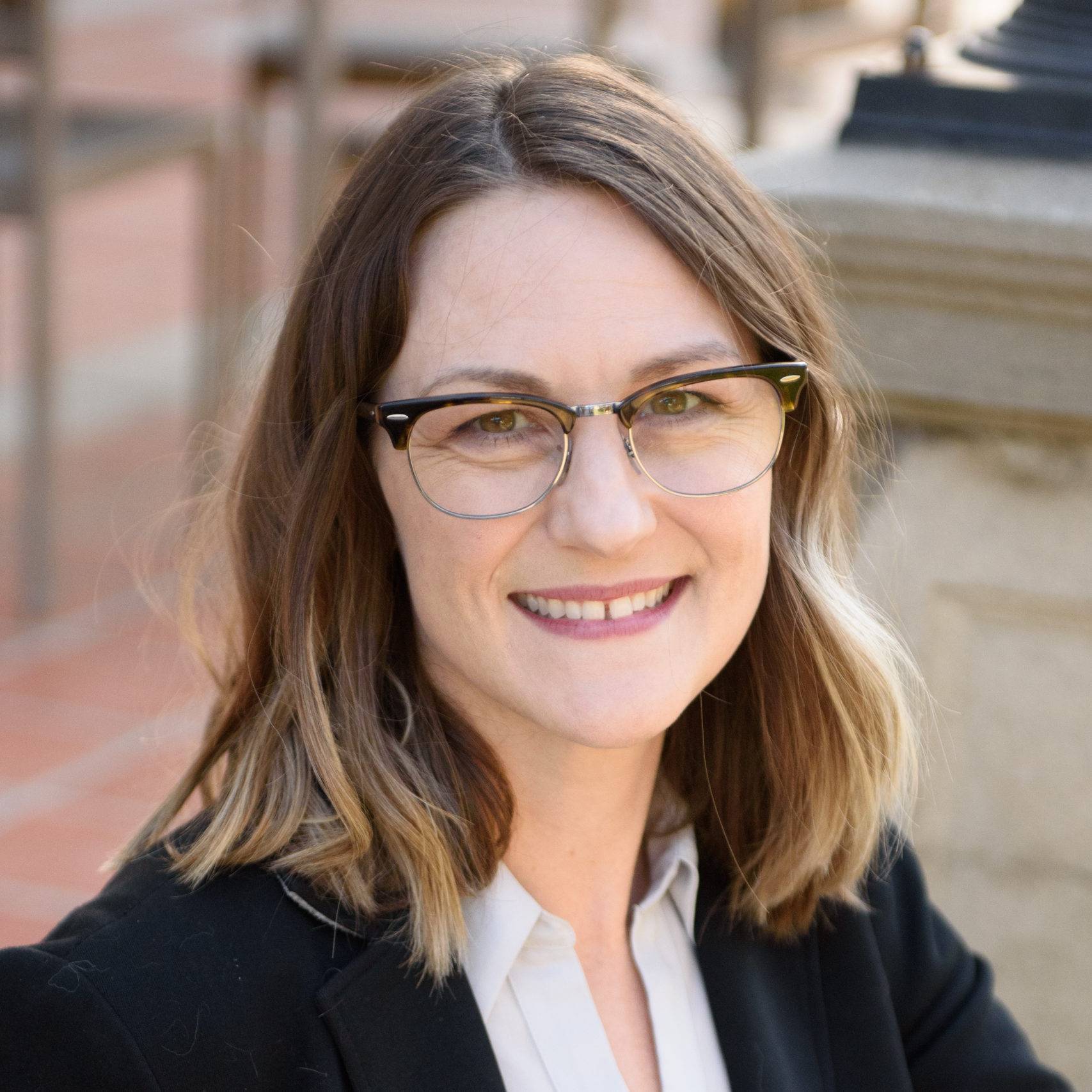 a person wearing glasses and smiling