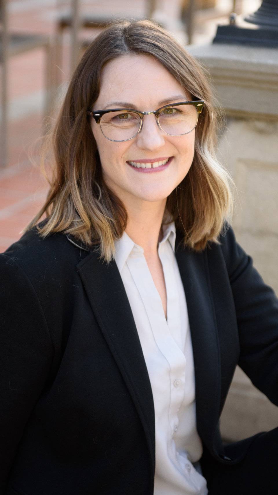 a person wearing glasses and a suit