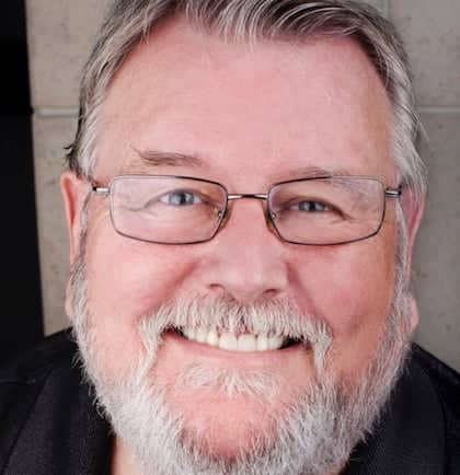 a person with glasses smiling