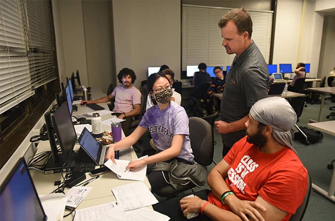 a group of people in a room with computers