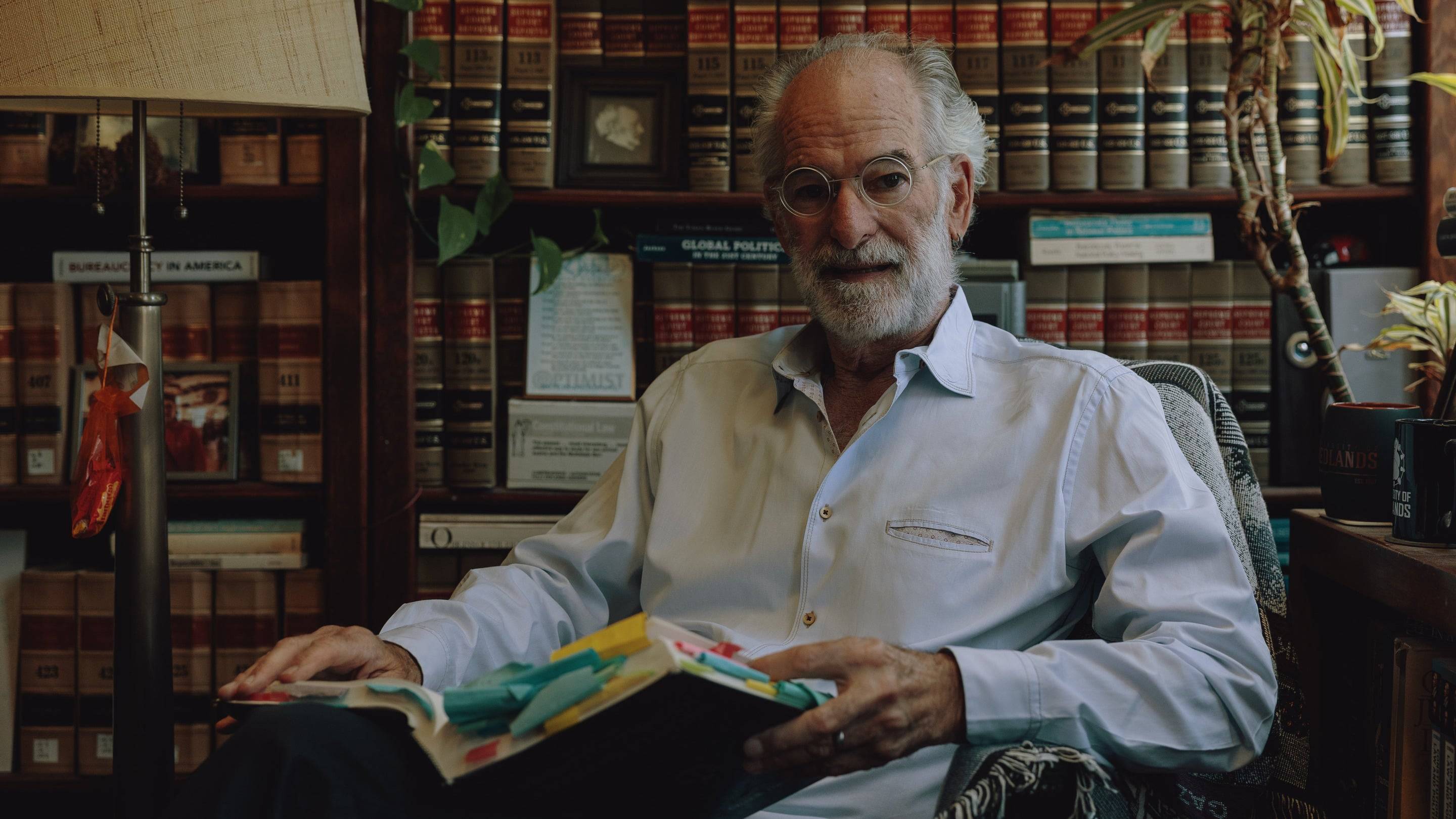 a person sitting in a chair with a book in his hands