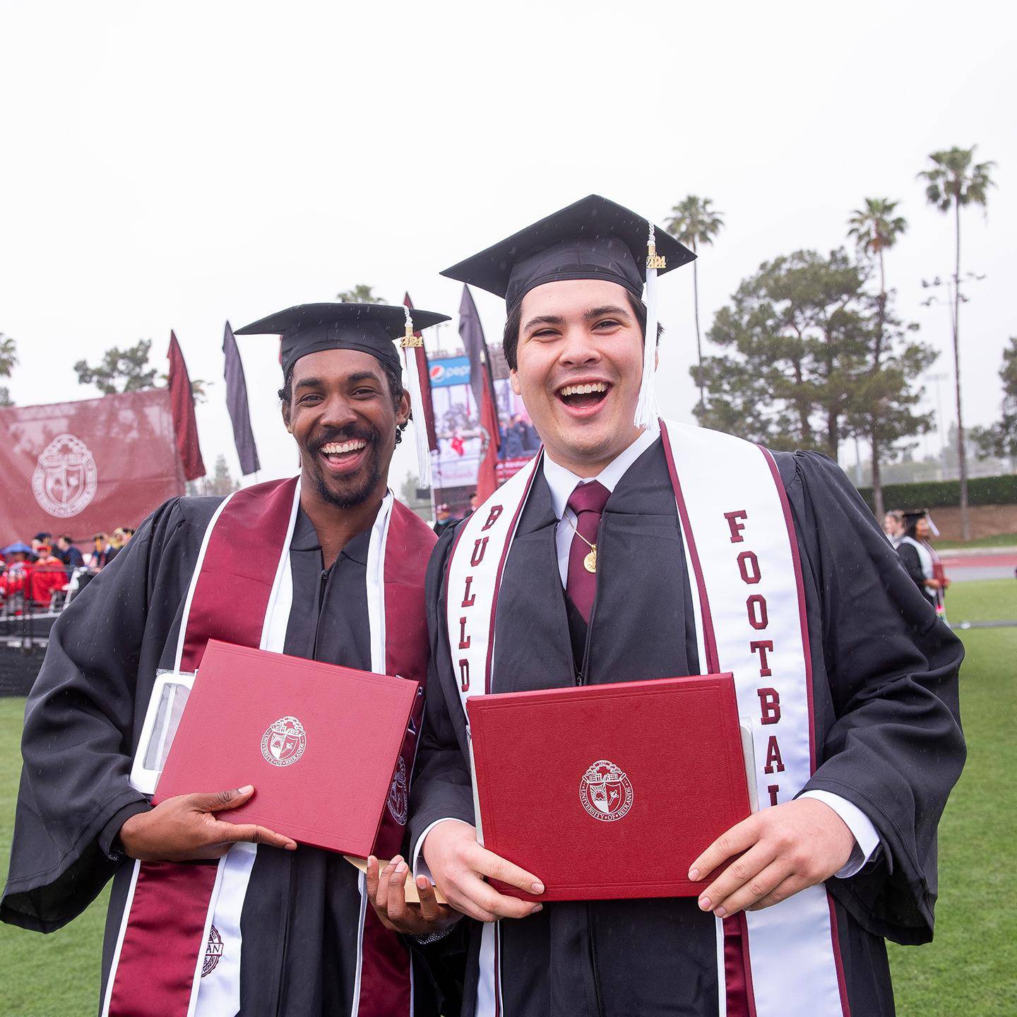 two men in graduation gowns and caps