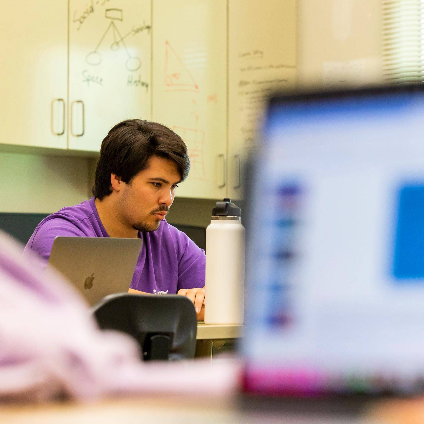 a person sitting at a desk with a laptop