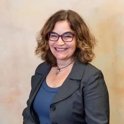 a person wearing glasses and a suit