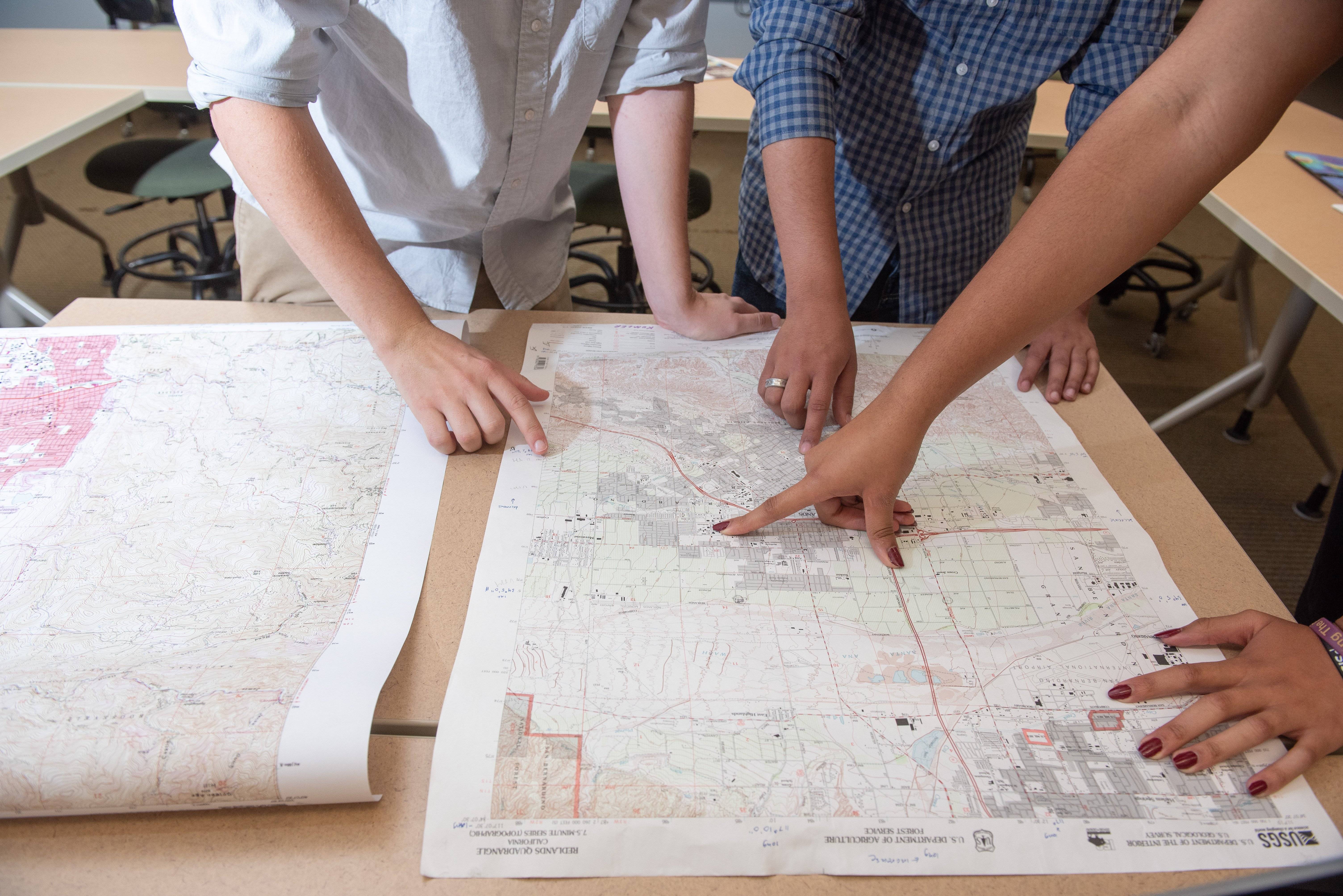 a group of people pointing at a map