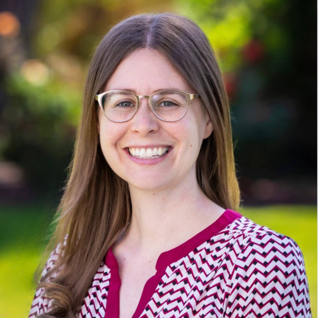 a person wearing glasses smiling