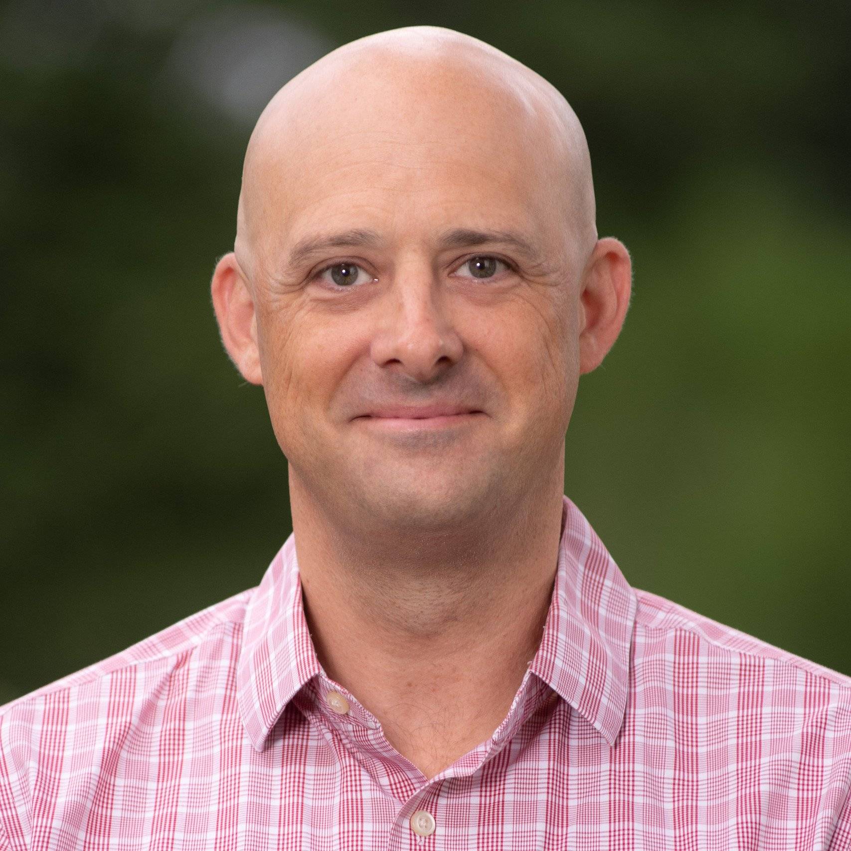 a bald person in a red and white checked shirt