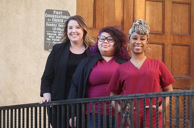 a group of women standing on a railing
