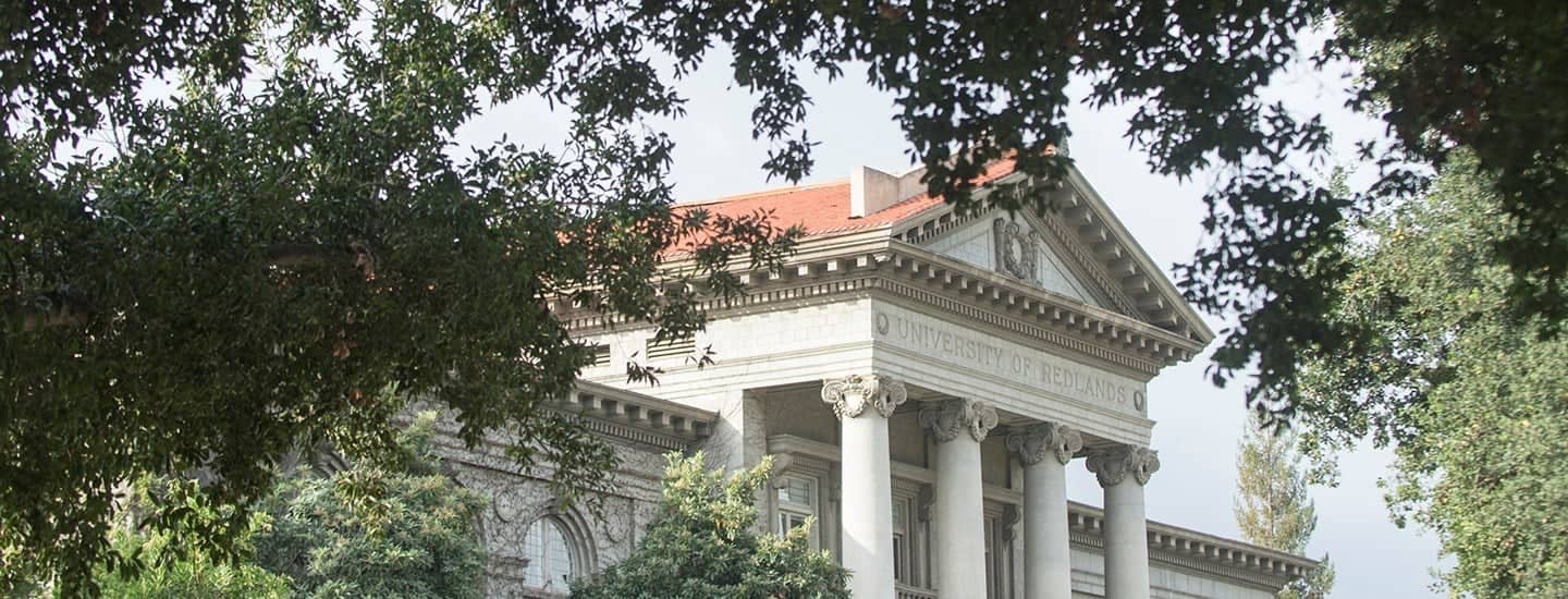 a building with columns and a red roof