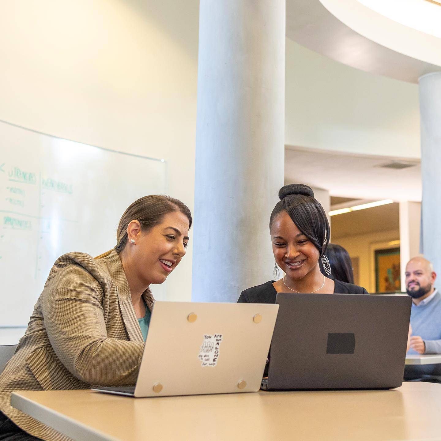a group of women looking at laptops