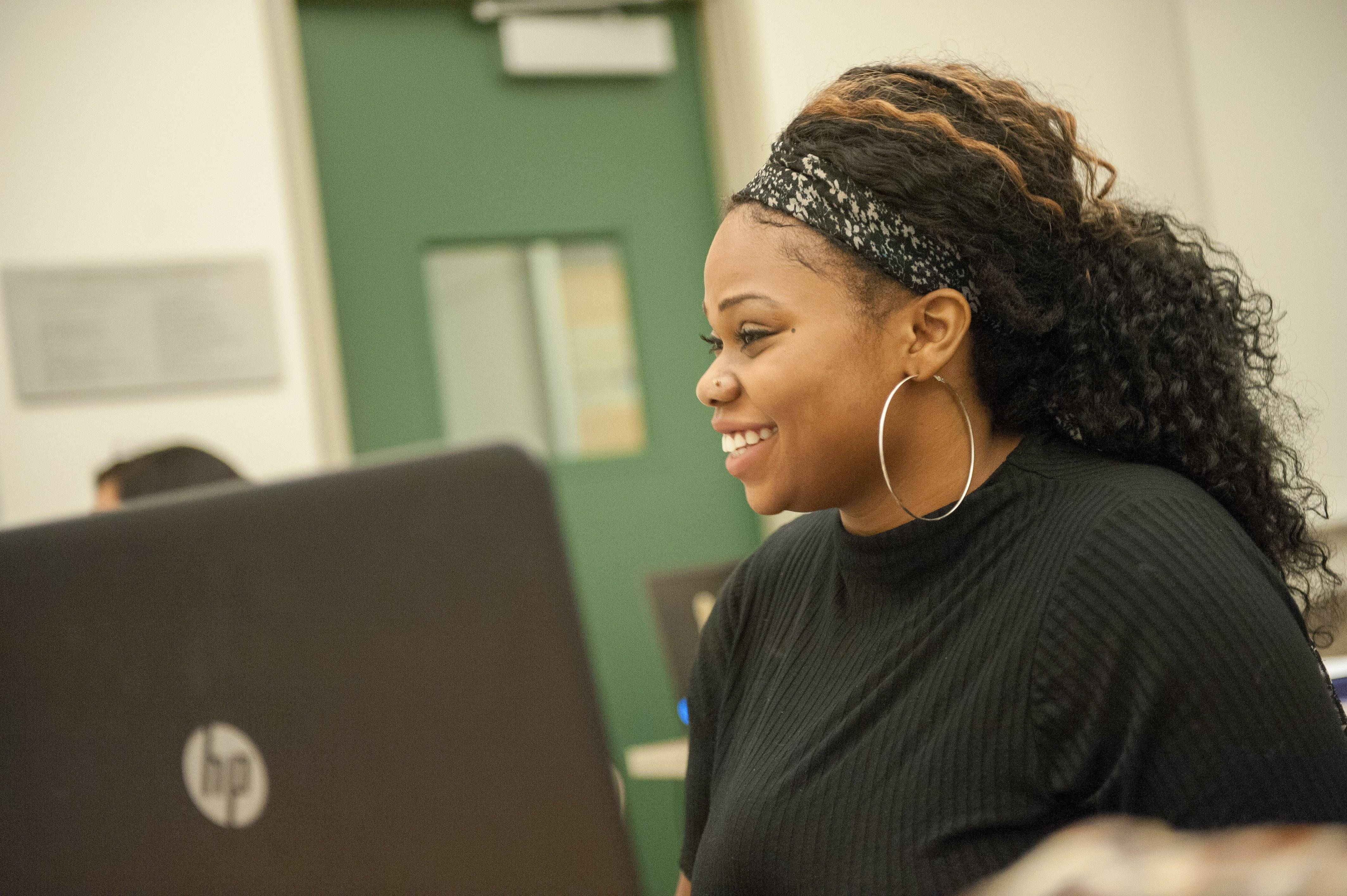 a person smiling at a laptop