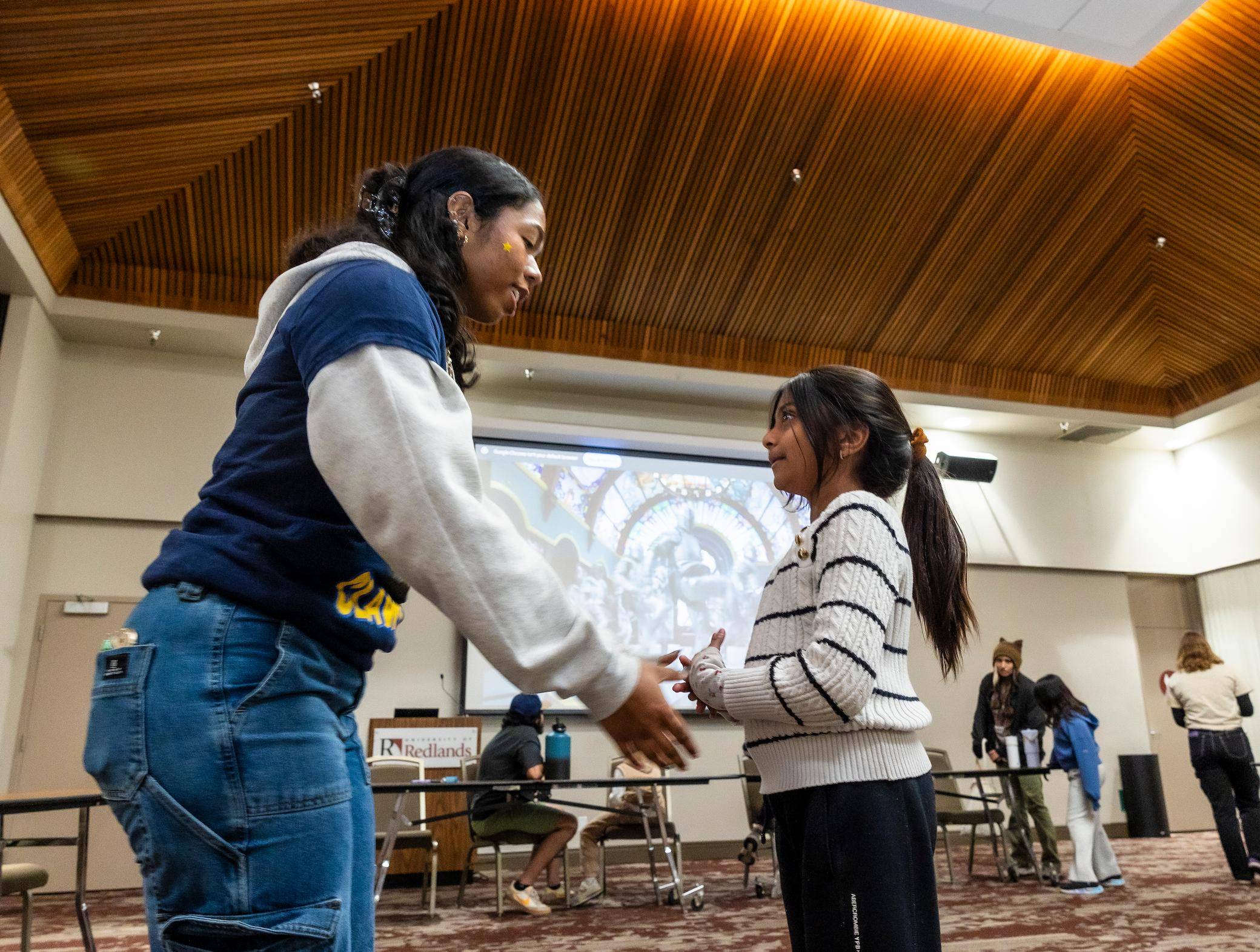 a two childs holding hands in a room