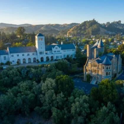 a building with a large tower and a parking lot in front of it