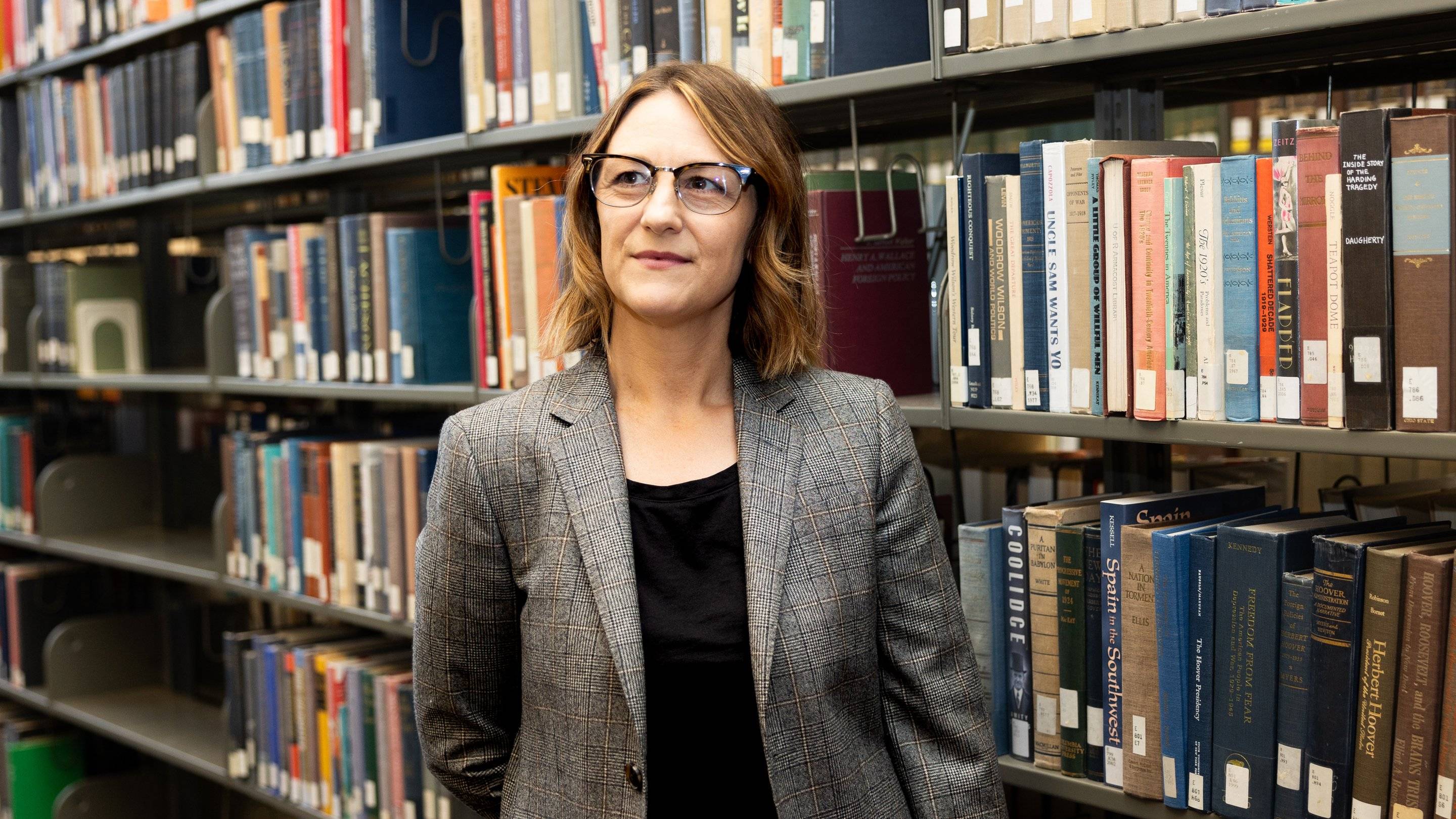 a person standing in front of a shelf of books