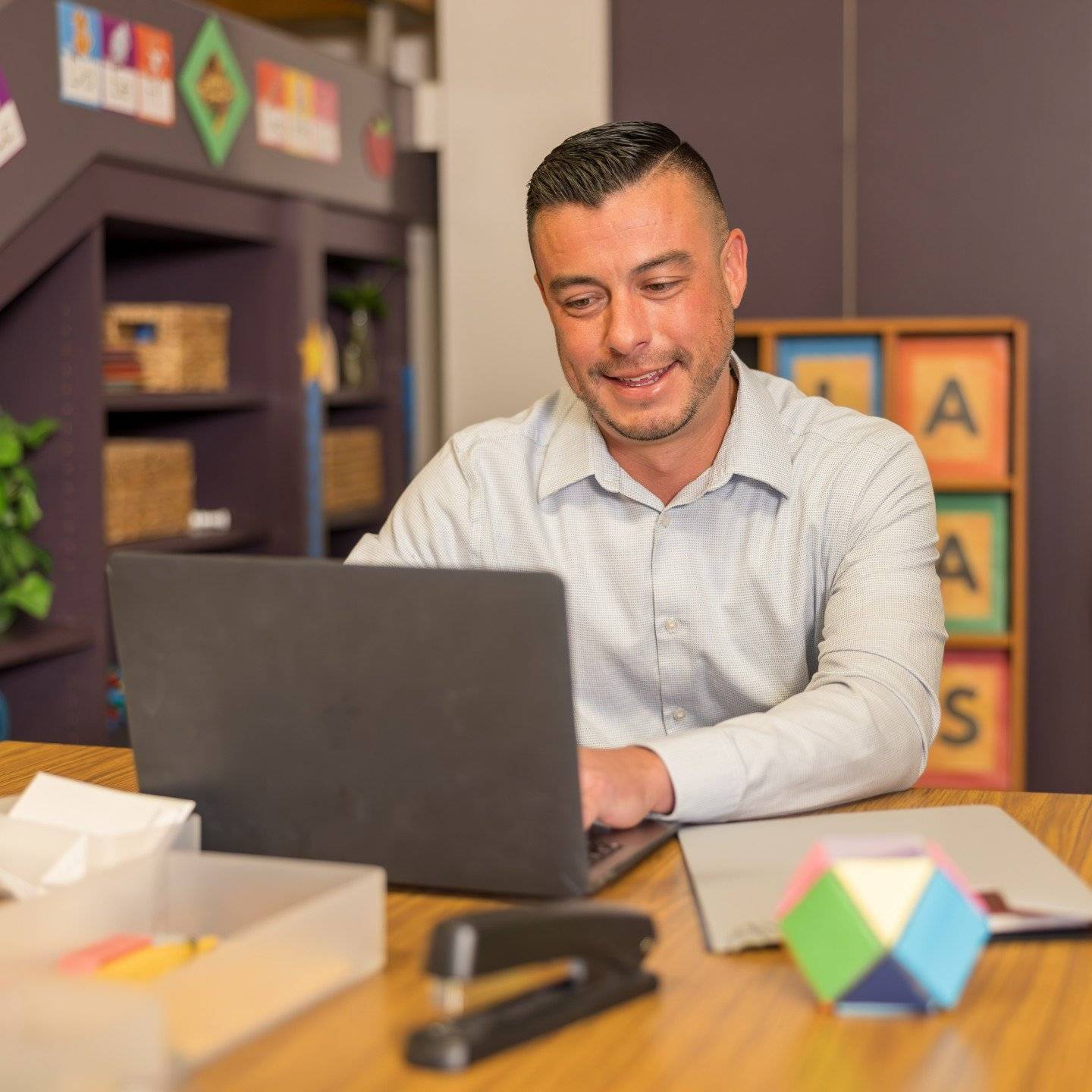 a person sitting at a desk using a laptop