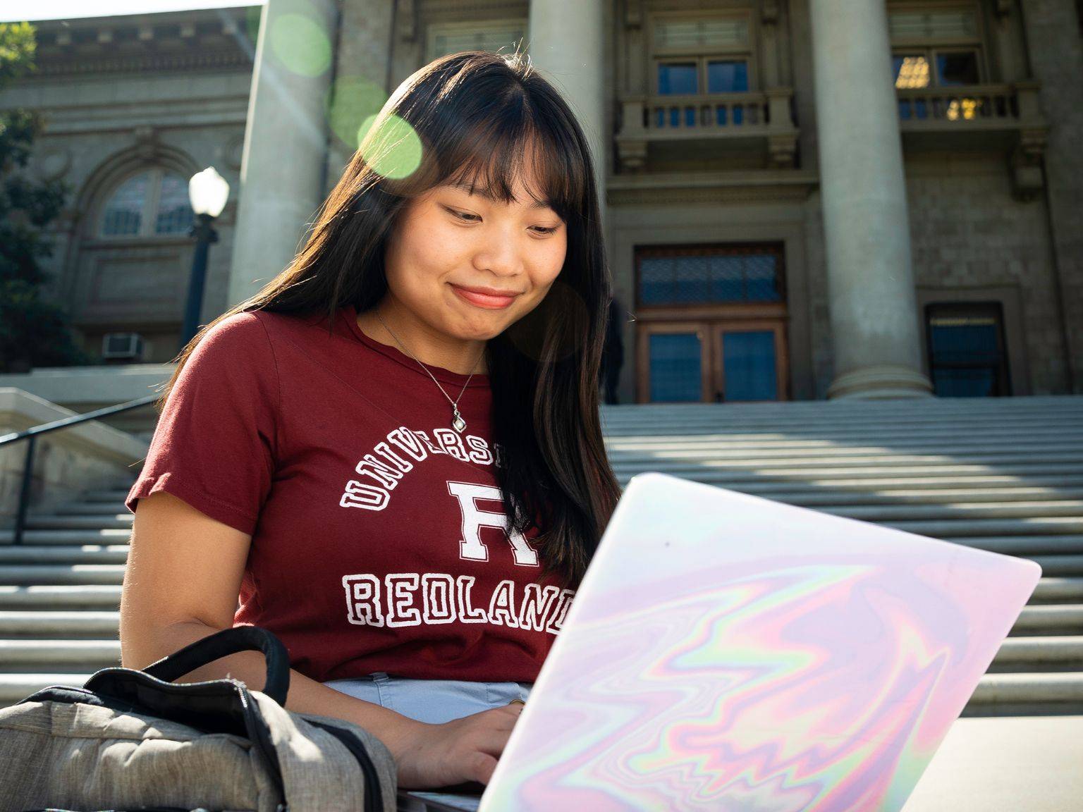 a person sitting on stairs with a laptop
