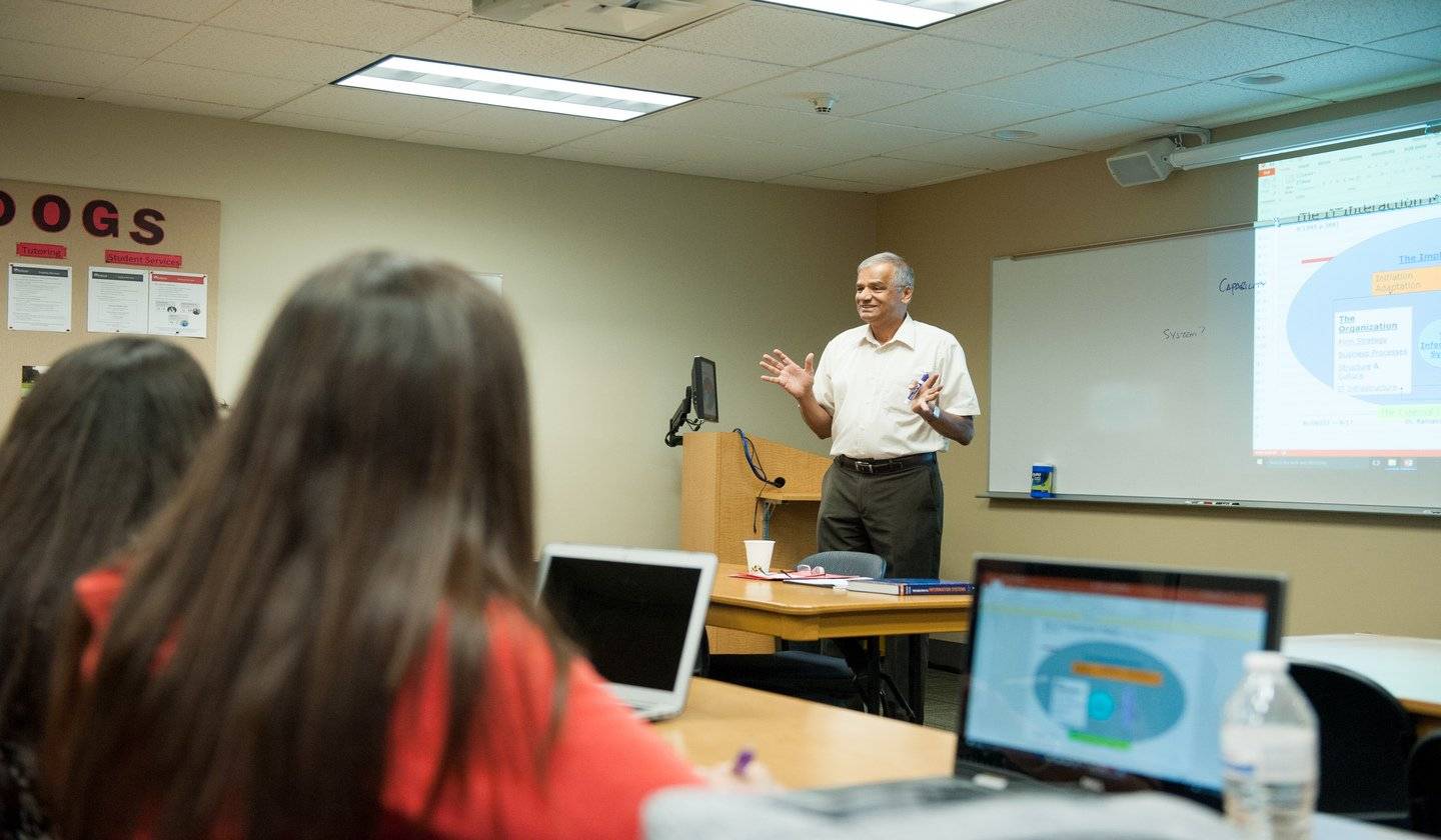 a person standing in front of a table with a person in the background