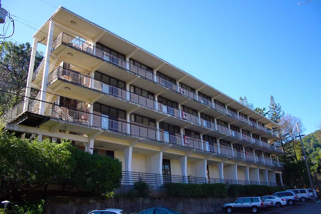 a building with balconies and cars parked in front of it