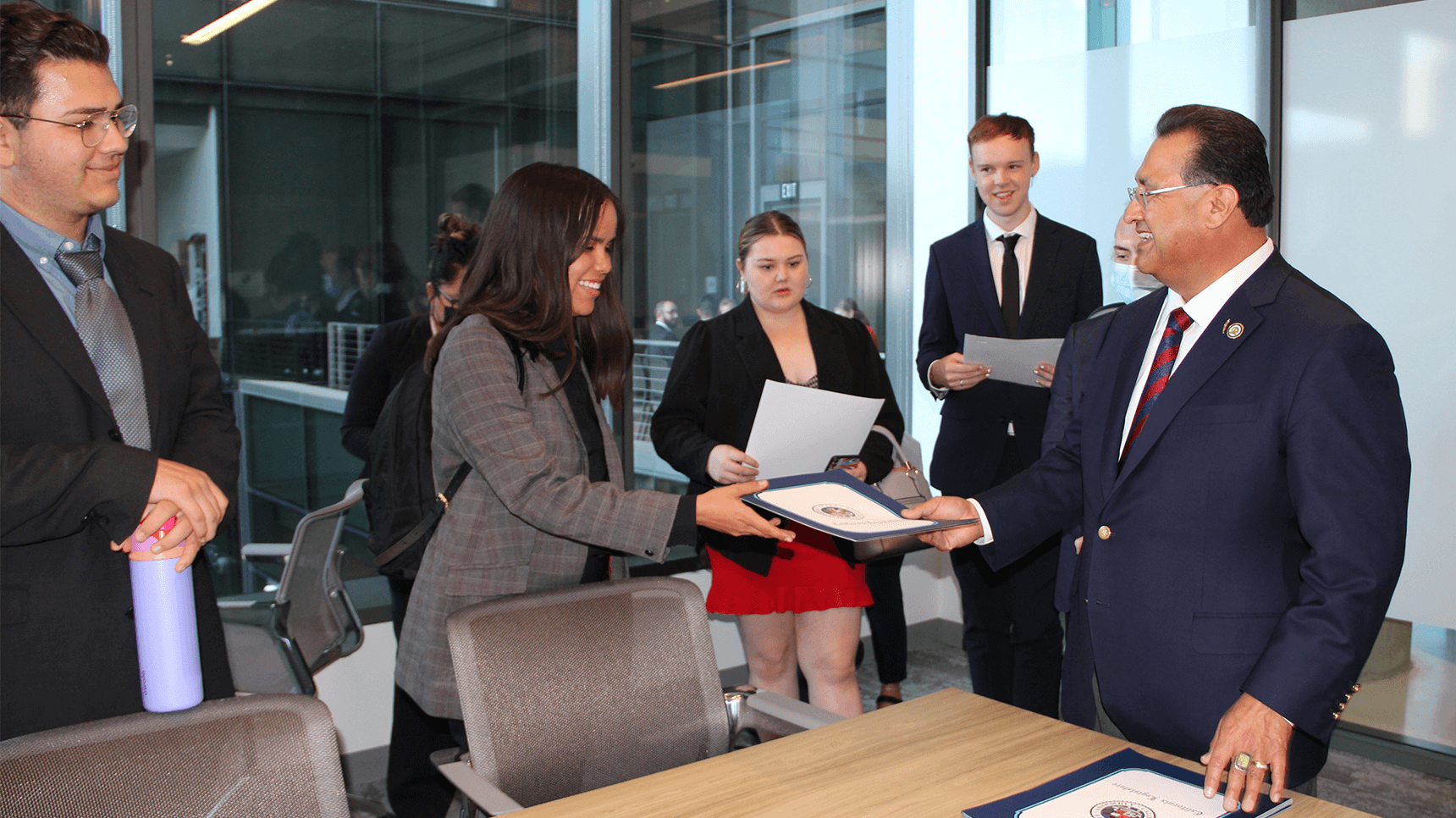 a person handing a document to a person