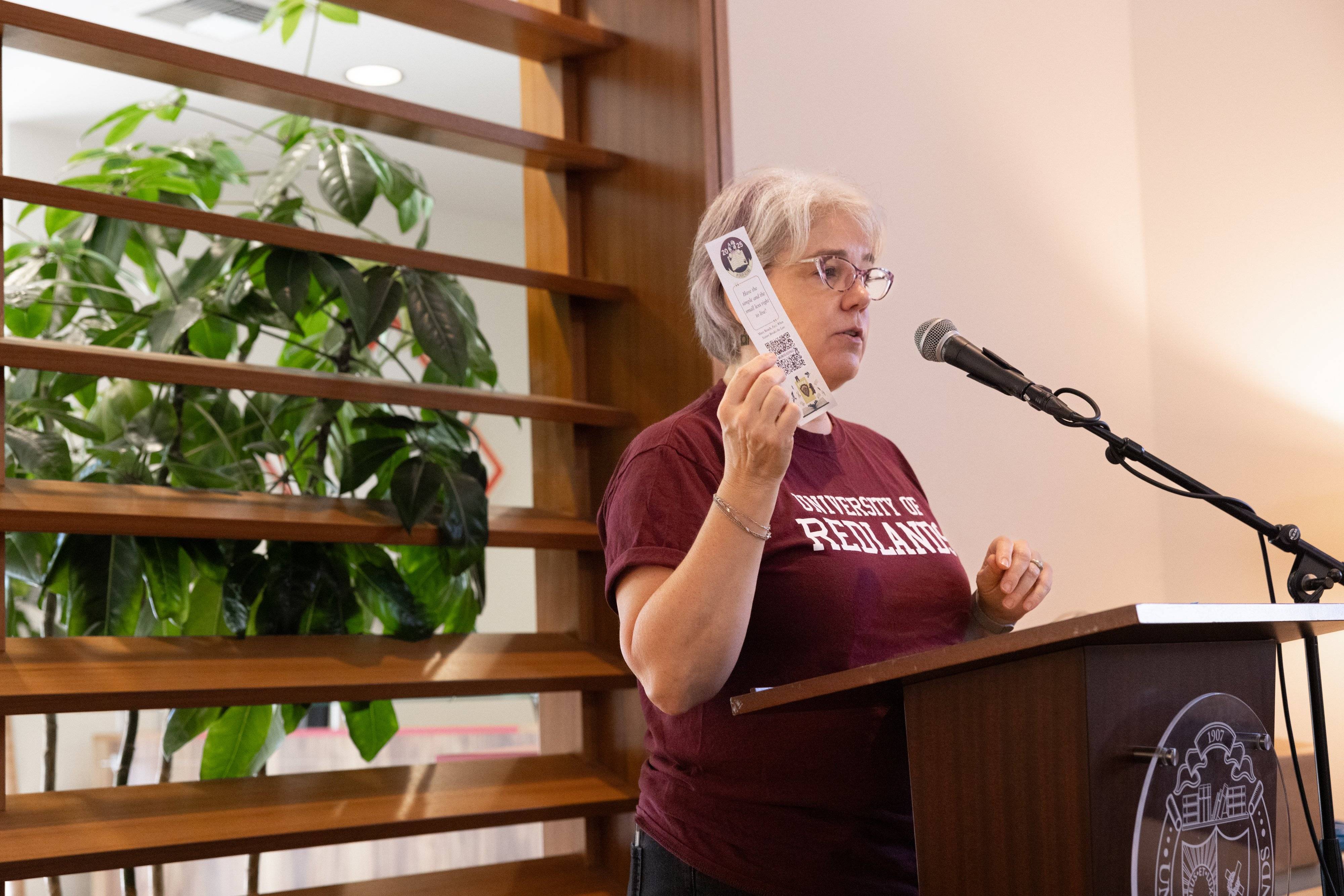 a person standing at a podium holding a piece of paper