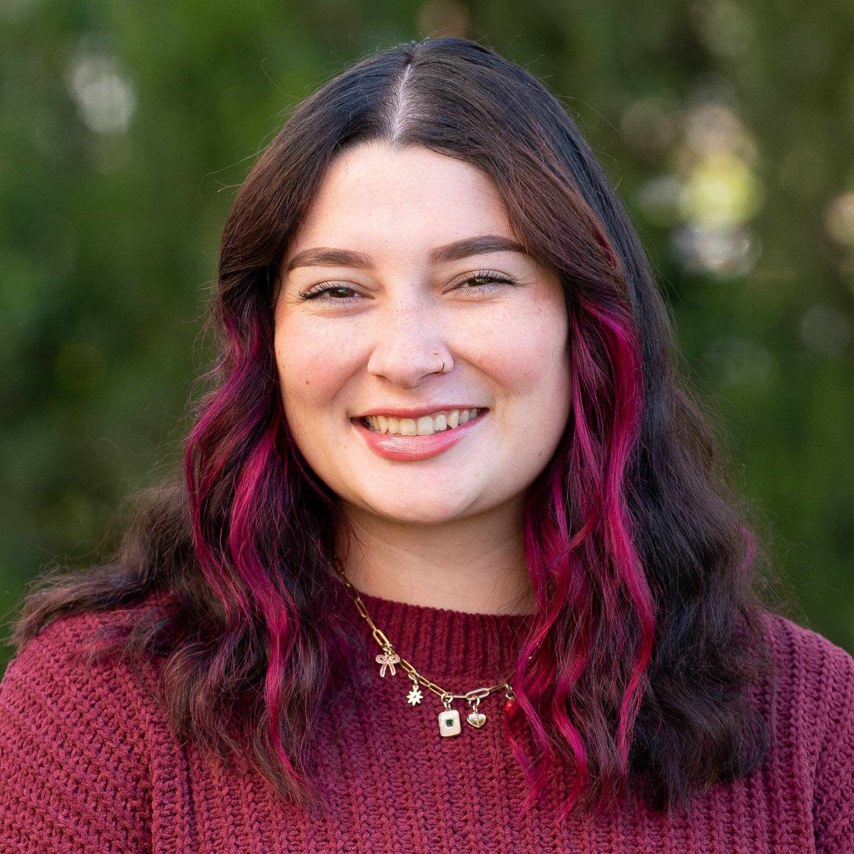 a person with pink hair smiling