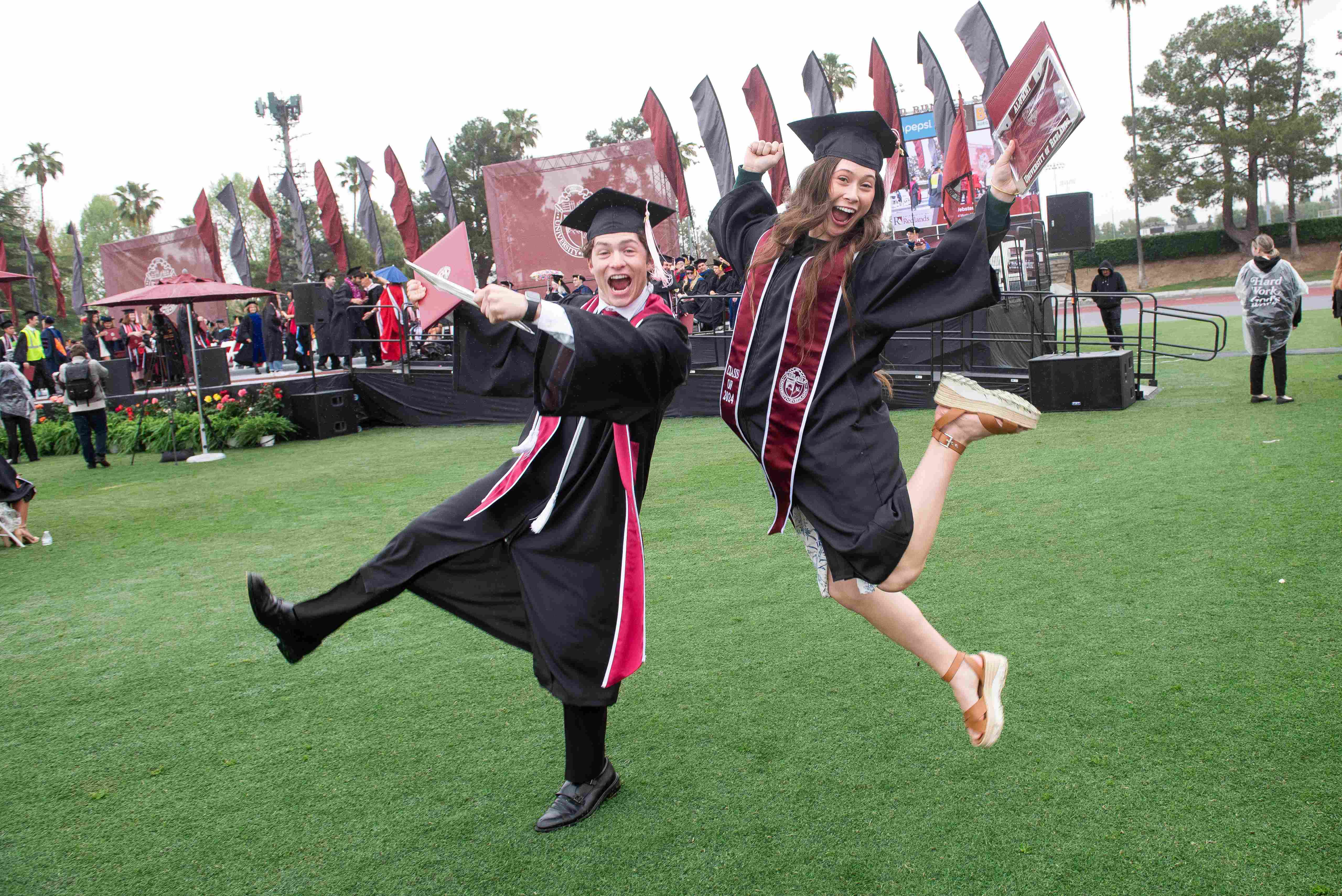 a person and person in graduation gowns jumping in the air