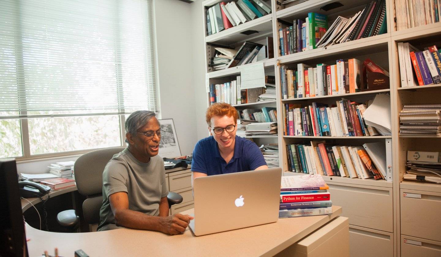 a person and person looking at a laptop