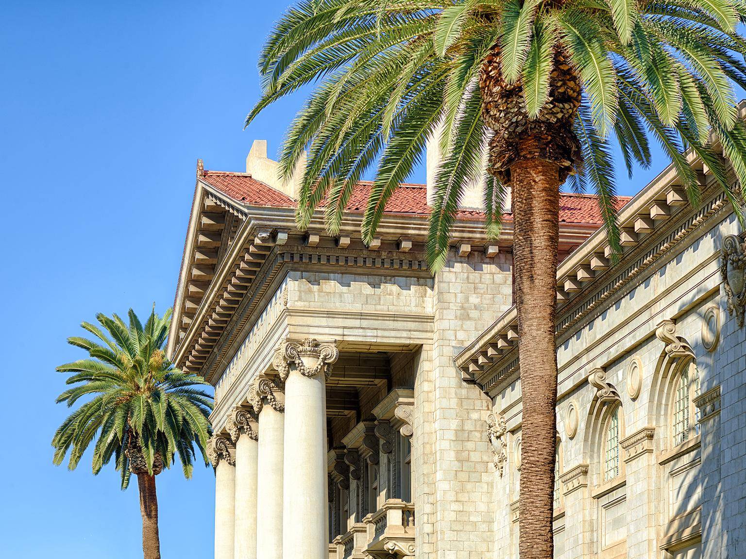 a building with columns and palm trees