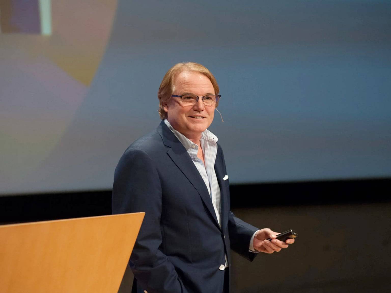 a person standing at a podium holding a phone