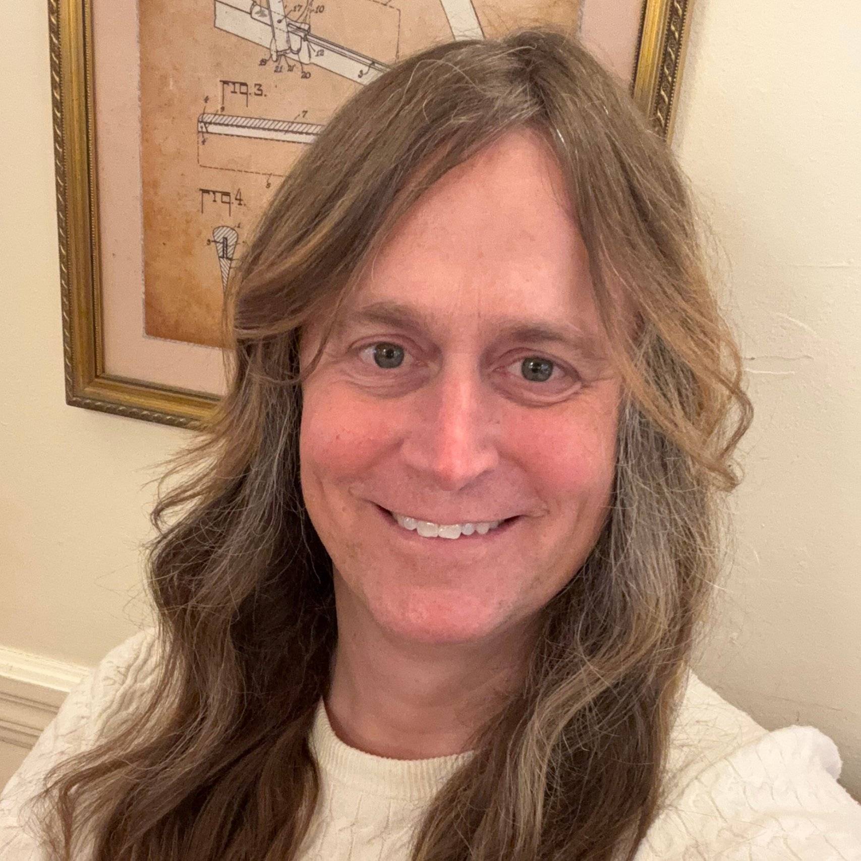 a person with long hair smiling