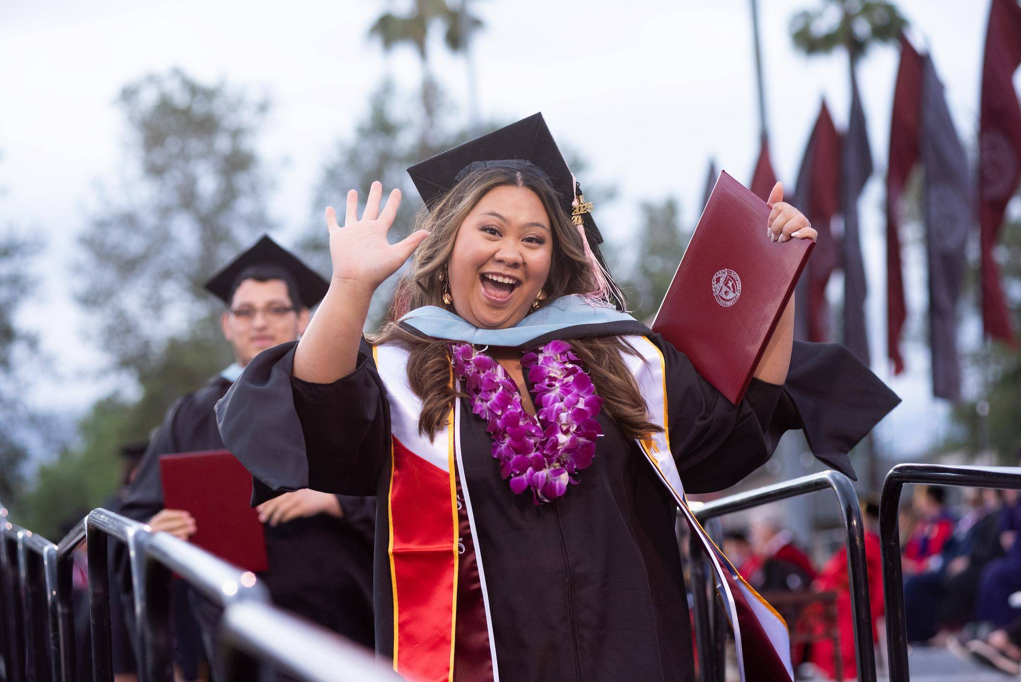 a person in a graduation gown holding a diploma