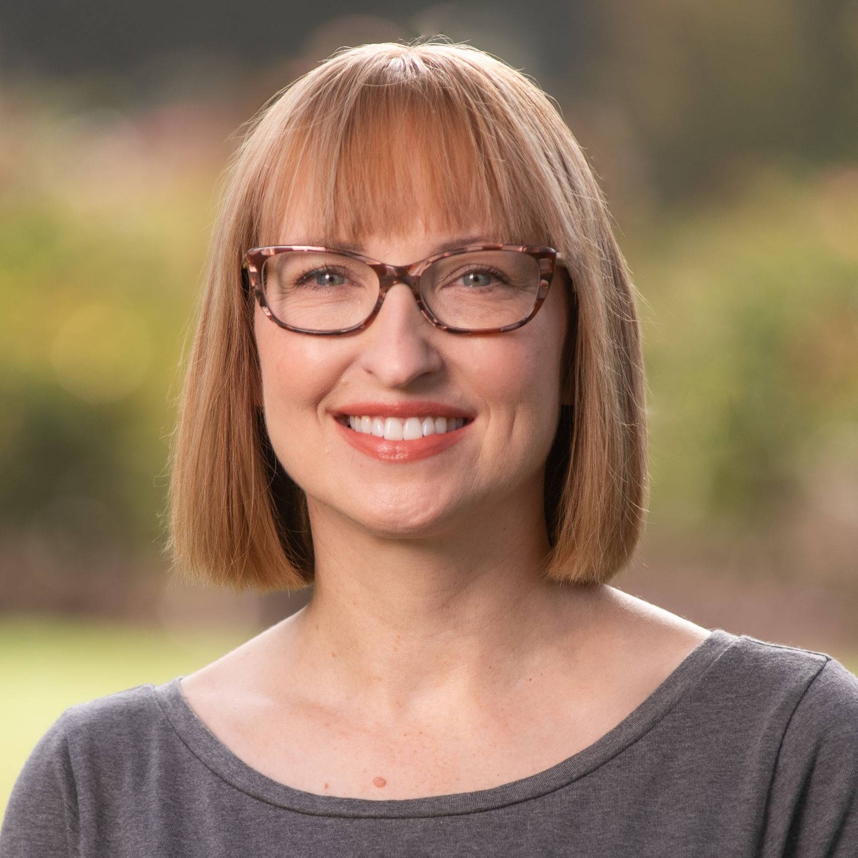 a person with short hair wearing glasses