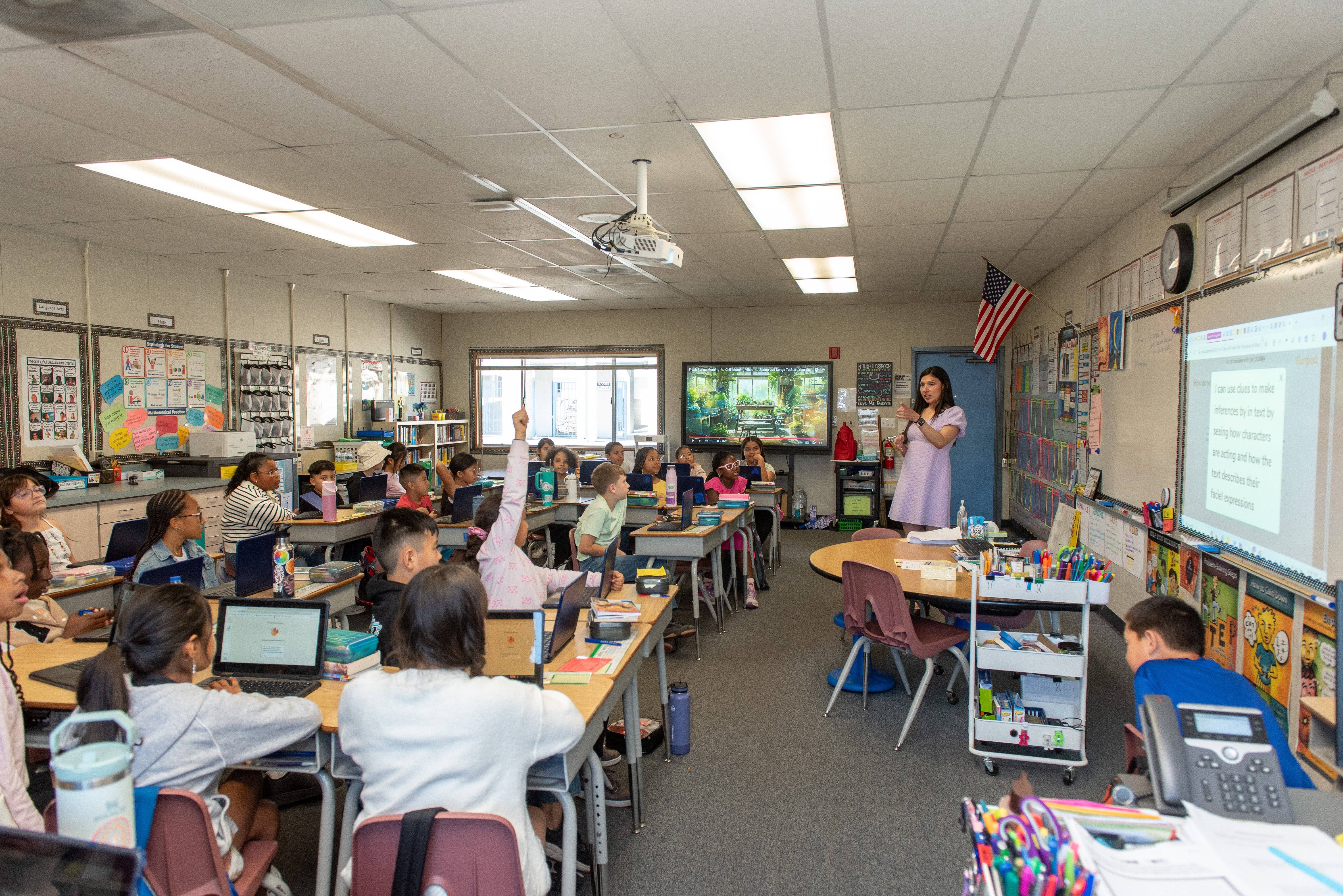 a person standing in front of a group of students in a classroom
