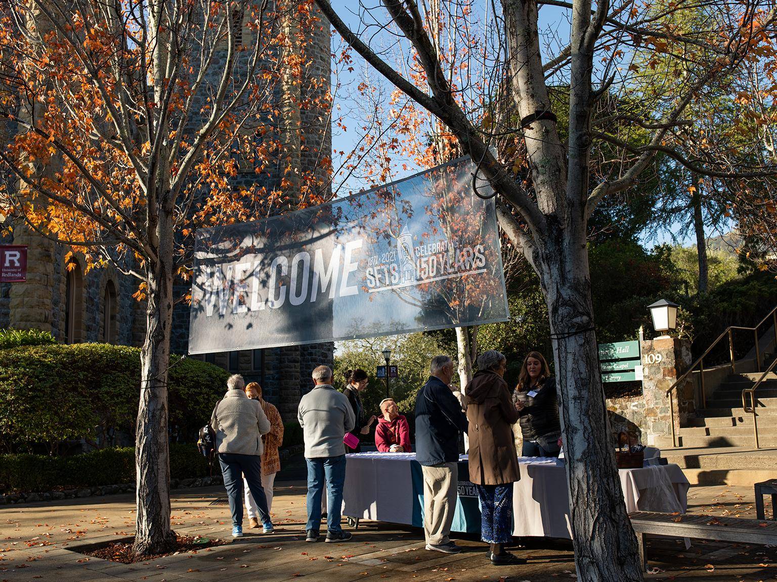 a group of people standing under a sign