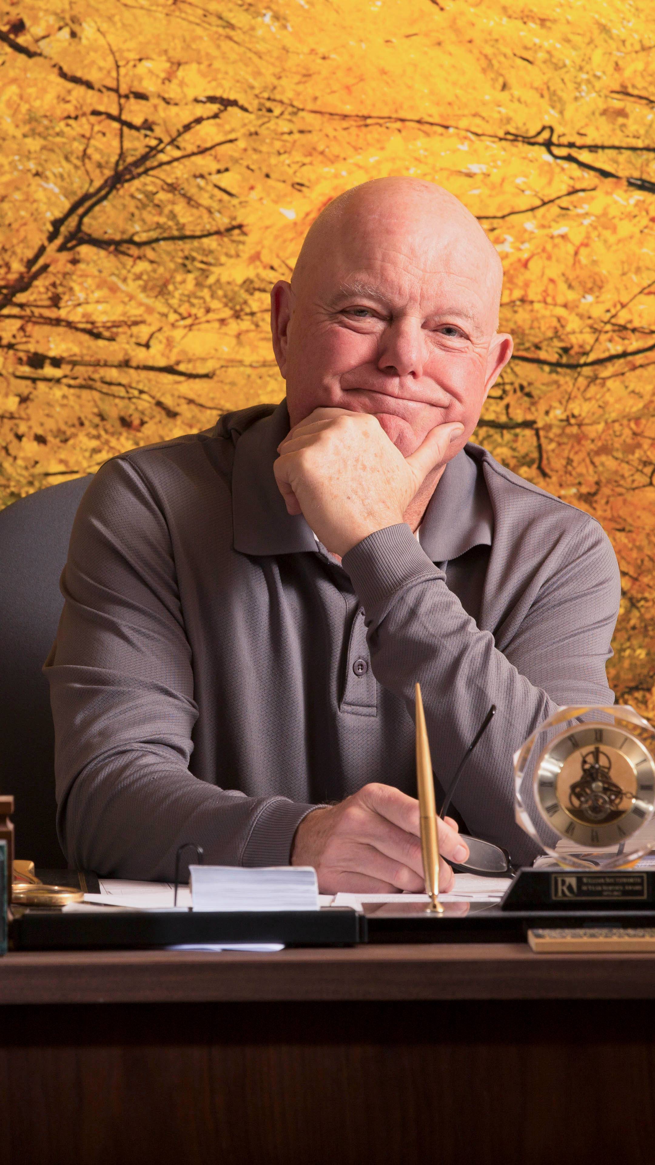 a person sitting at a desk with a pen and a trophy