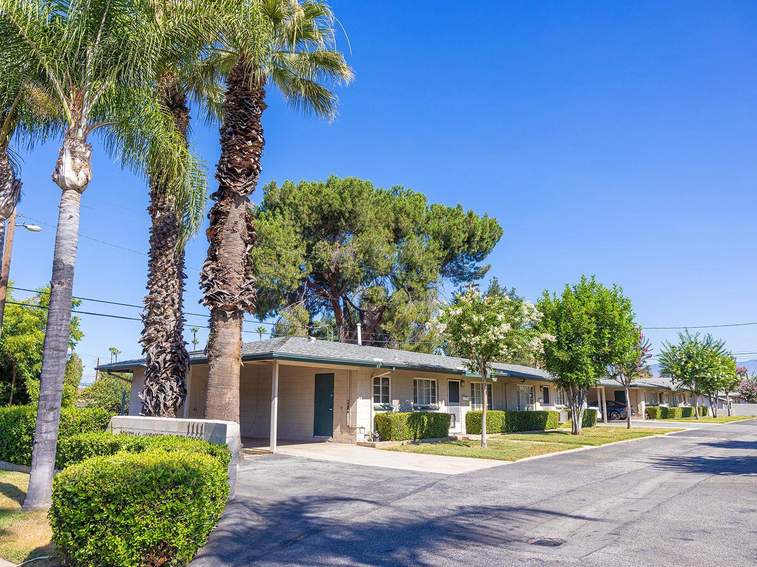 a row of houses with trees and bushes