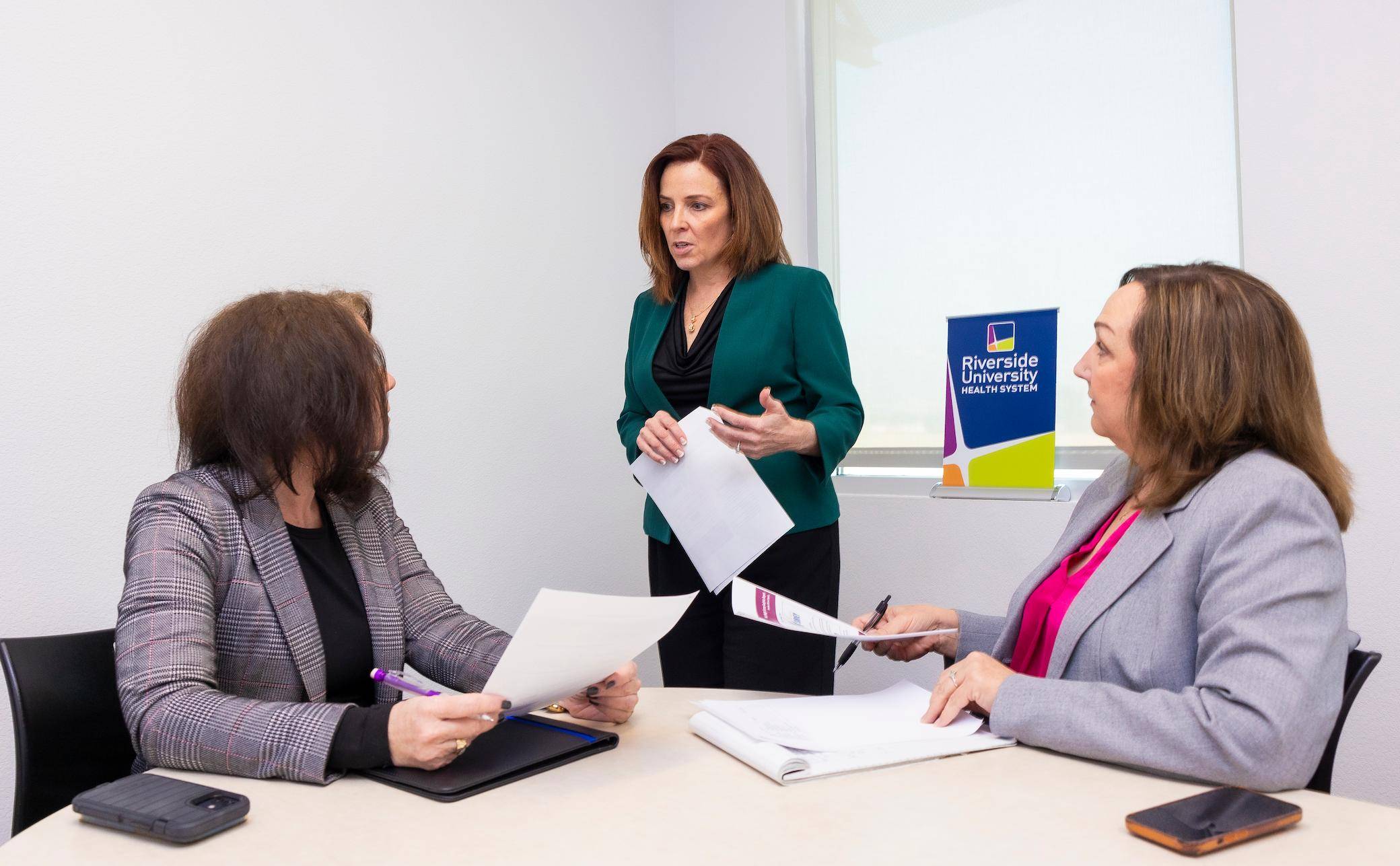 a person standing in front of a group of women
