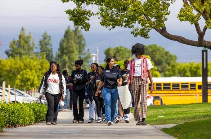 a group of people walking on a sidewalk