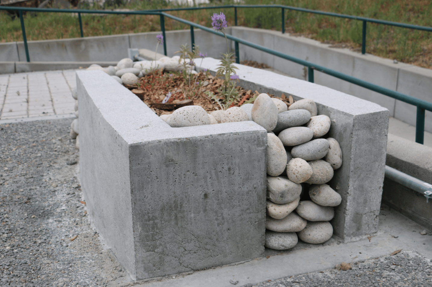 a stone planter with rocks and plants in it