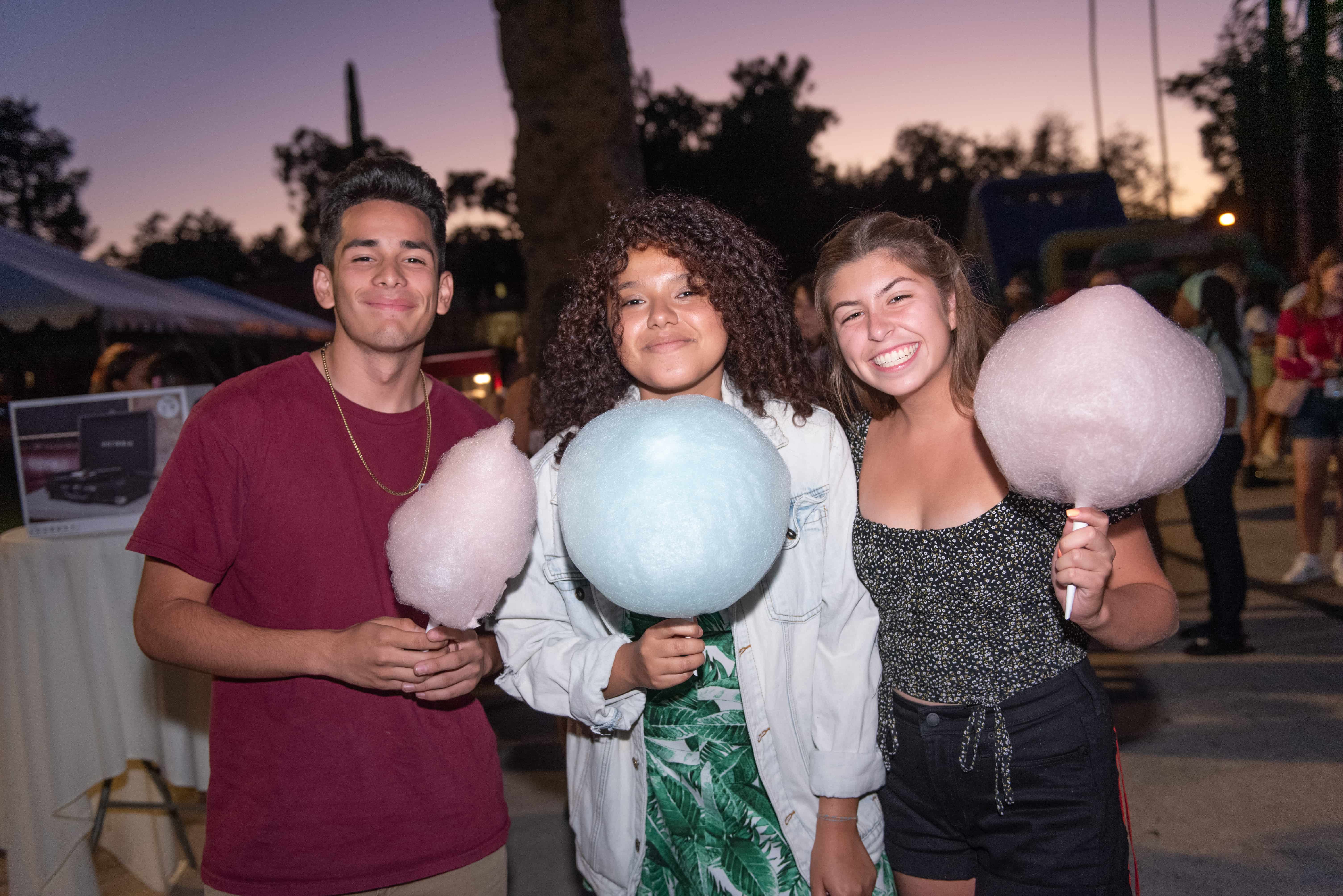 a group of people holding cotton candy