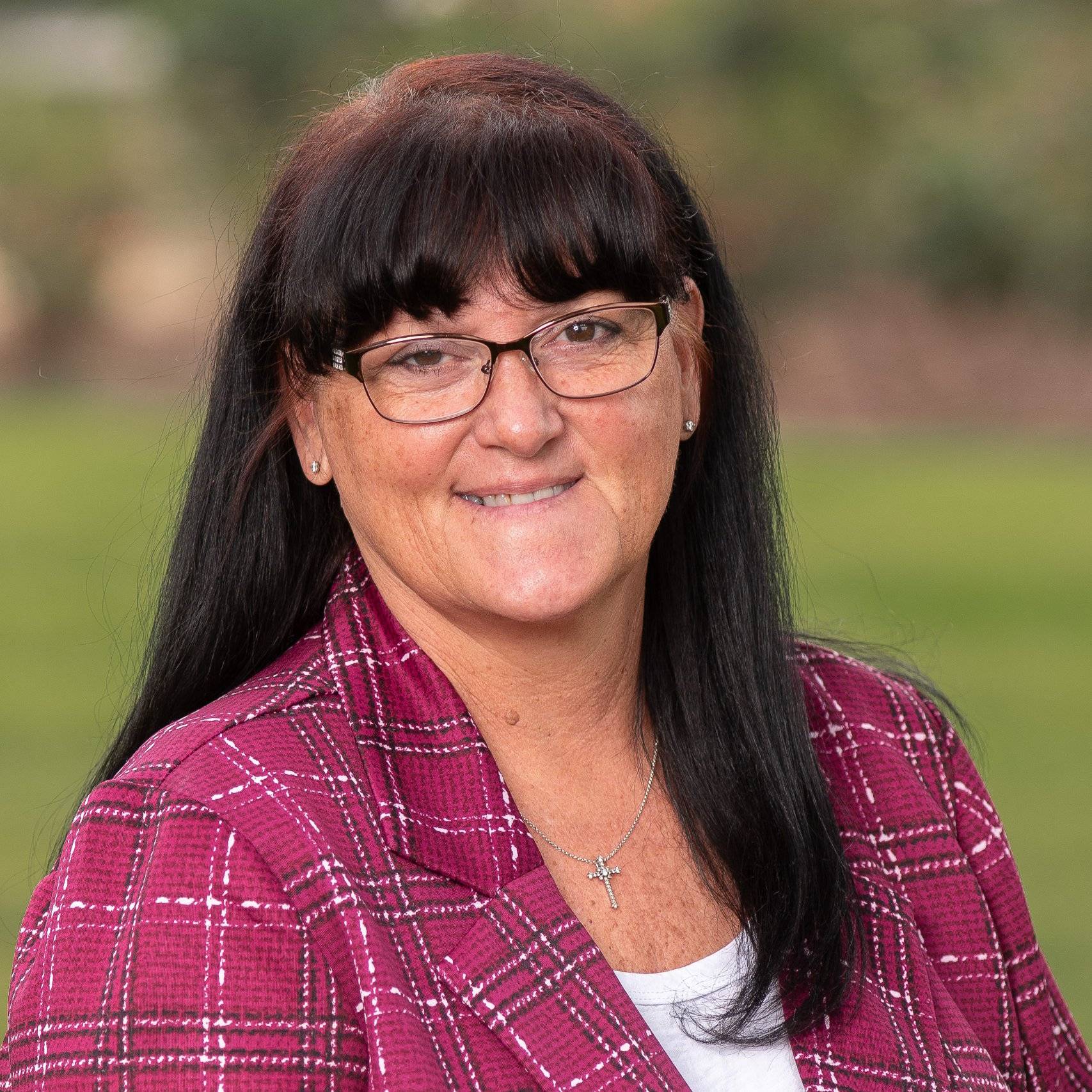 a person wearing glasses and a red plaid jacket