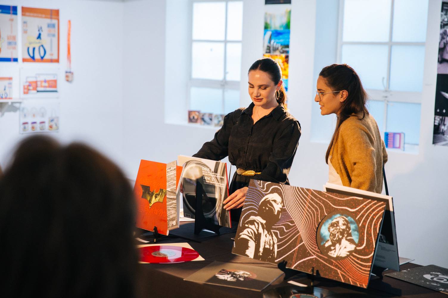 a group of women looking at a record album