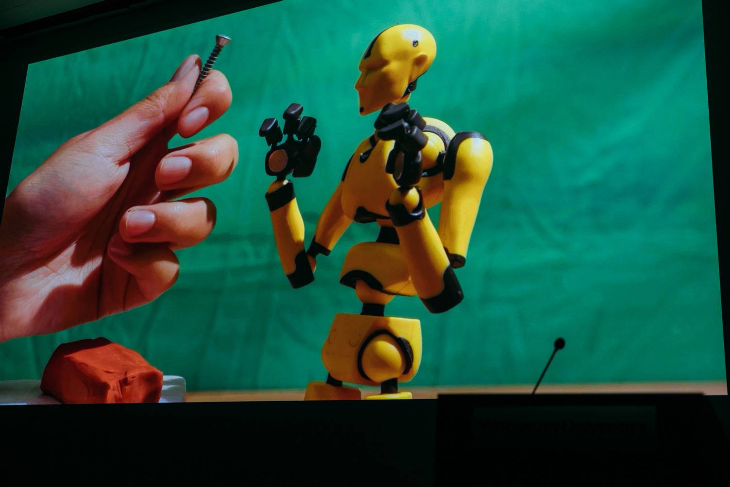a hand holding a yellow robot
