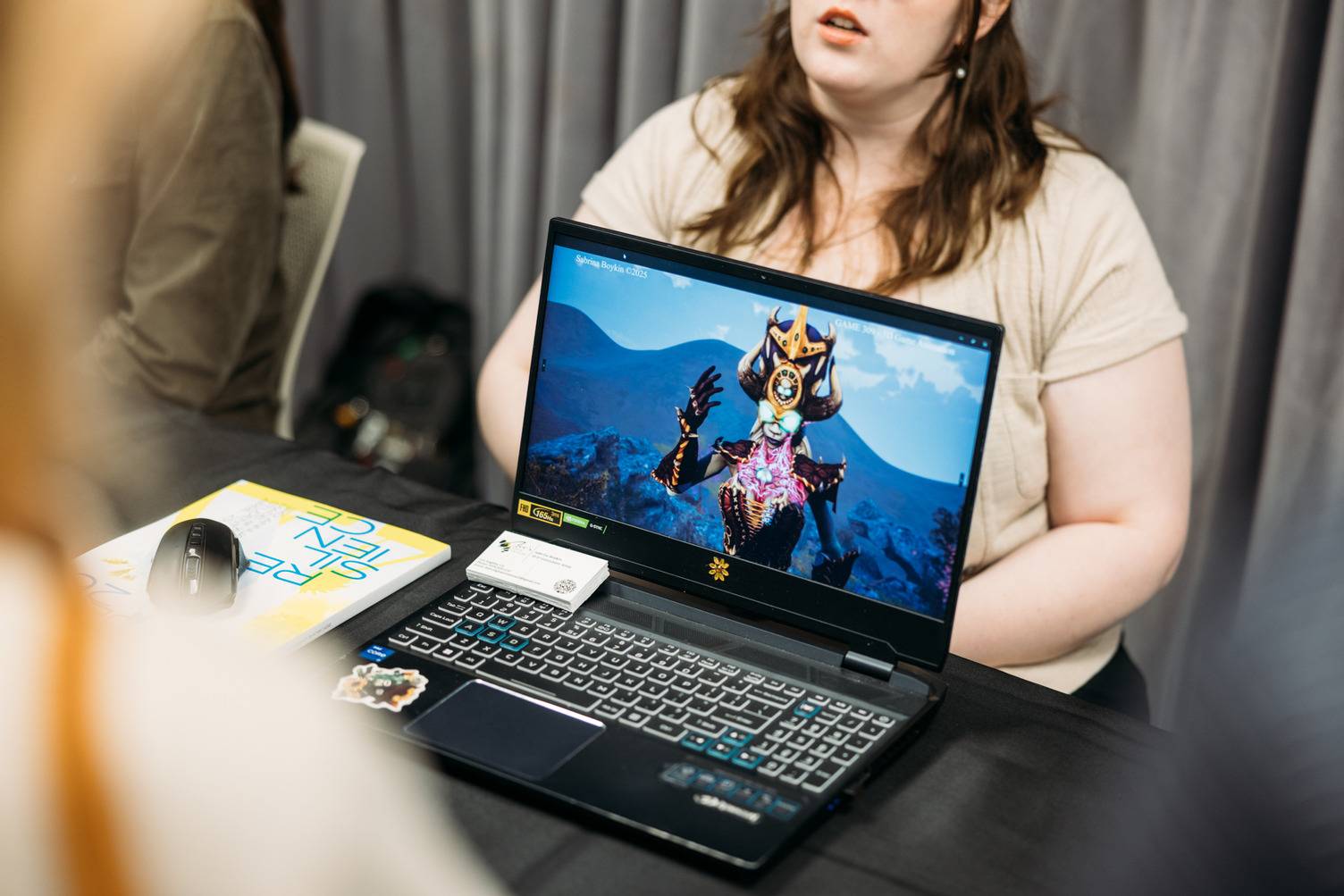 a person sitting at a table with a laptop