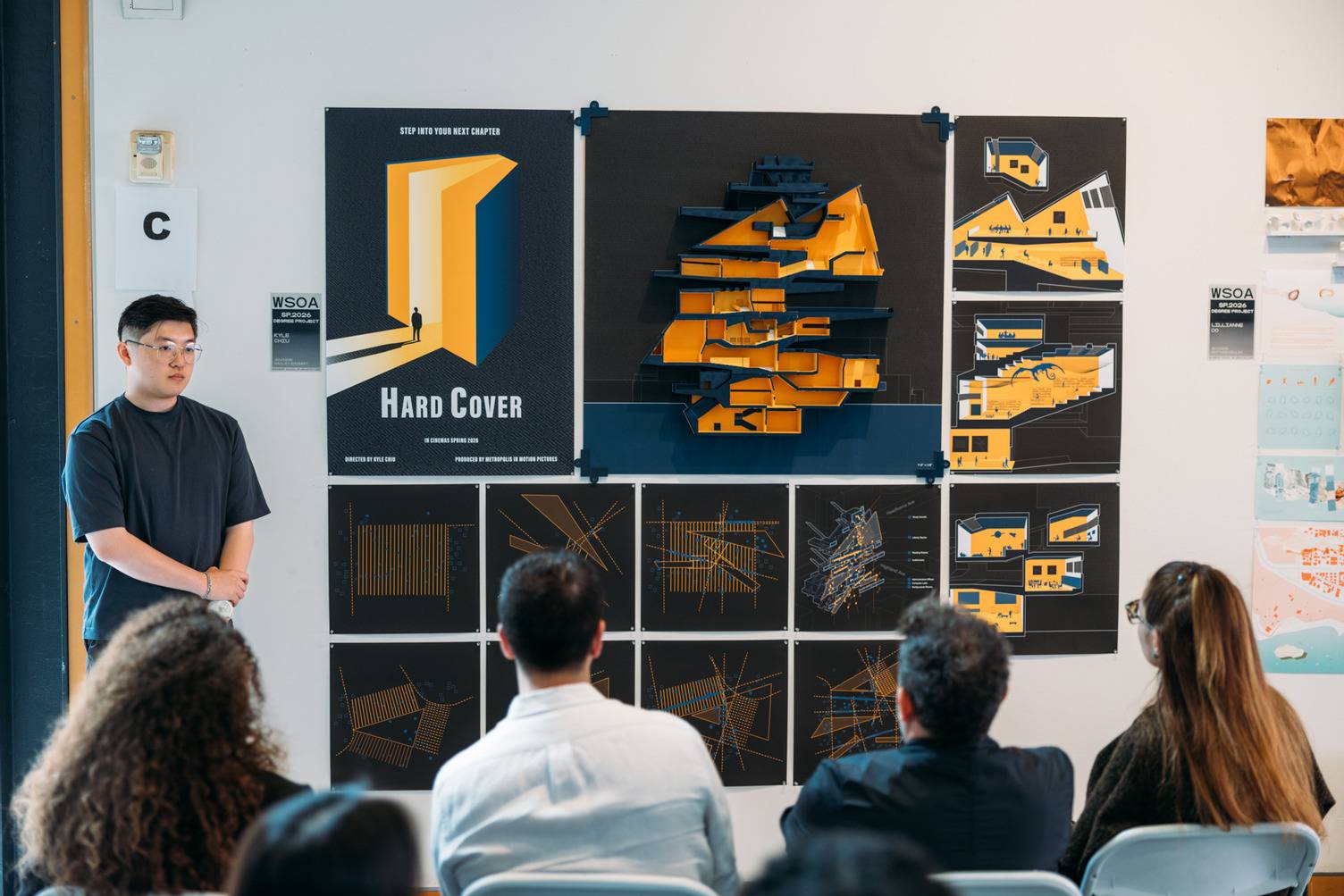 a group of people sitting in chairs in front of a poster