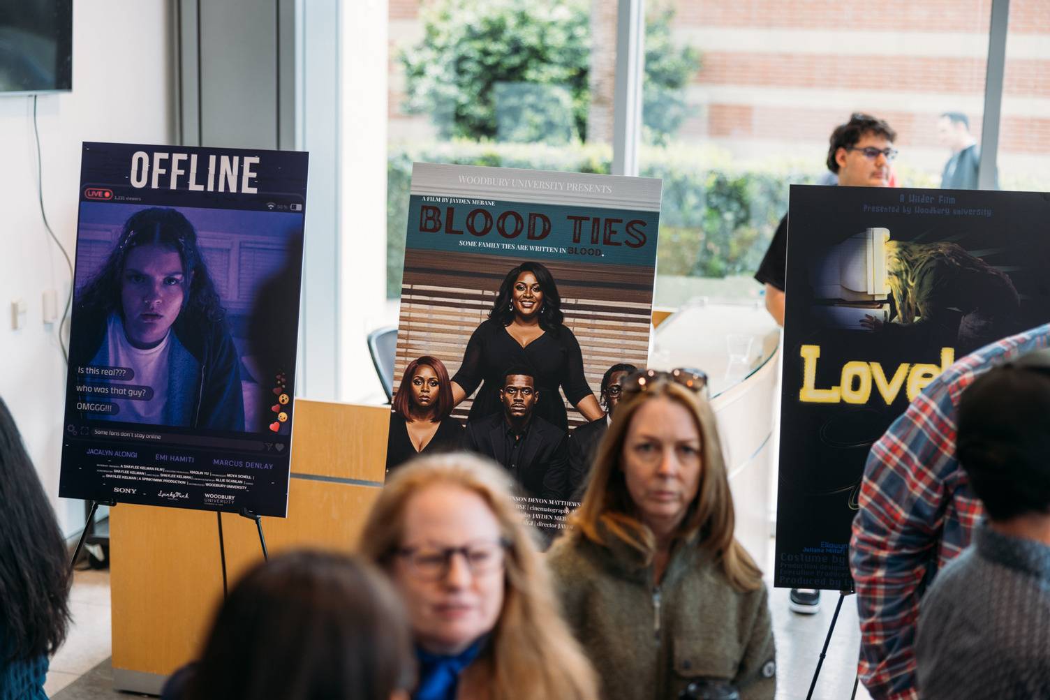 a group of people standing in front of posters