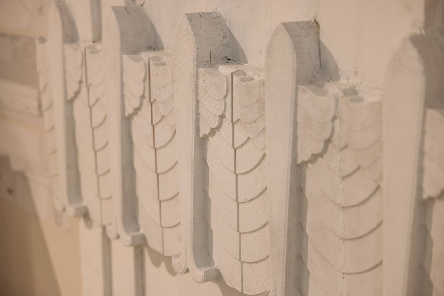 a white wall with a row of white decorative objects
